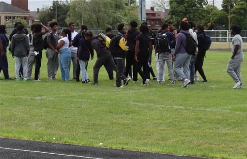 A group of students standing on green grass